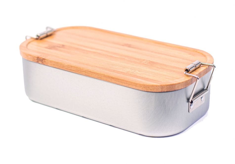 Geschlossene rechteckige Lunchbox aus silberfarbenem Metall mit seitlichen Clips und fest verschlossenem Bambusdeckel, neutraler Hintergrund.