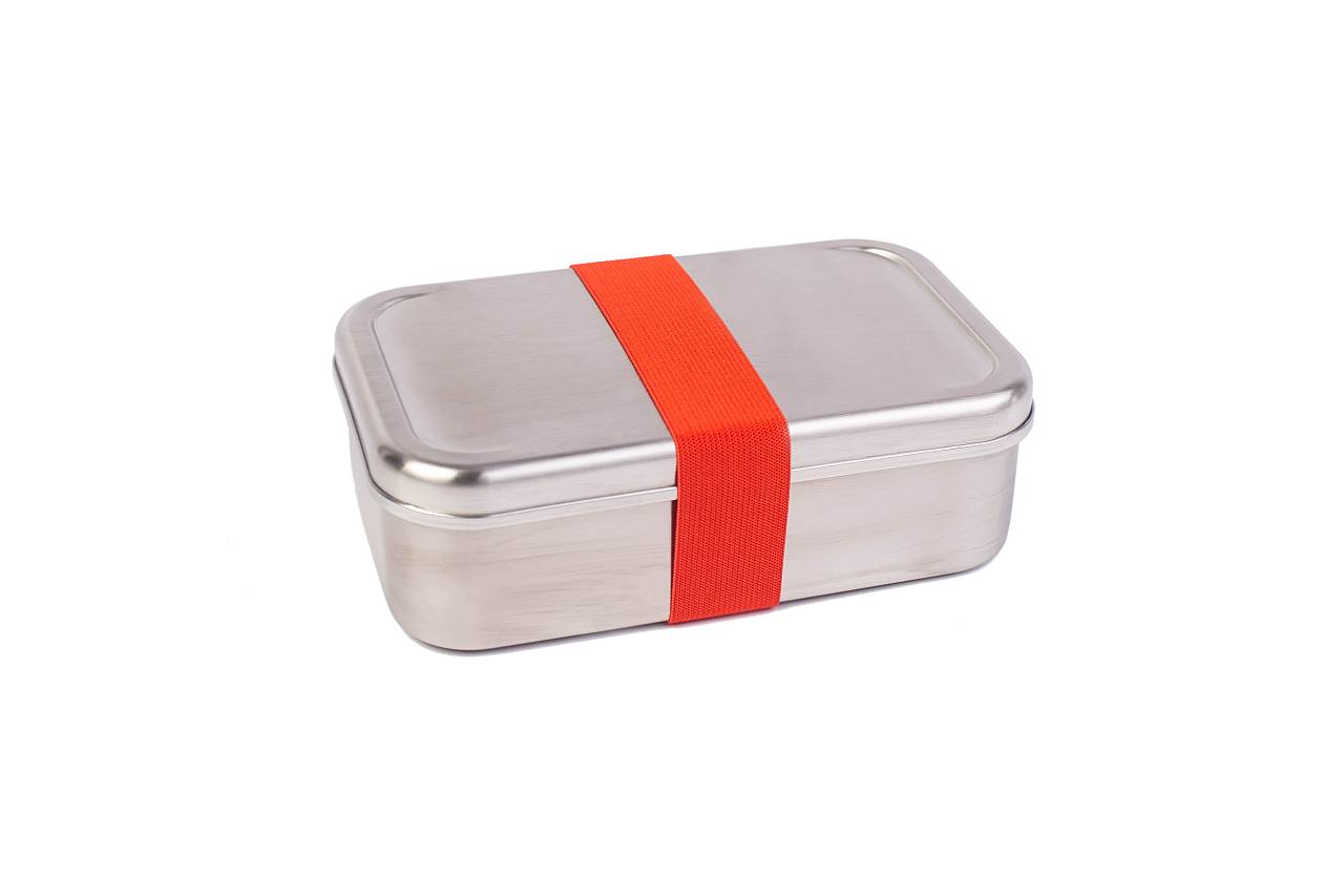 Rechteckige Lunchbox aus Edelstahl, geschlossen, mit umlaufendem roten Gummiband als Verschluss, auf weißem Hintergrund.