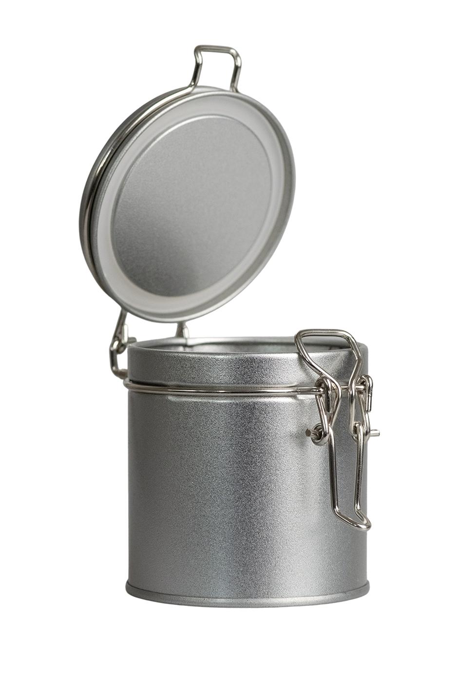 Geöffnete kleine runde Vorratsdose aus silberfarbenem Metall mit aufgeklapptem Bügelverschlussdeckel, stehend auf weißem Hintergrund.